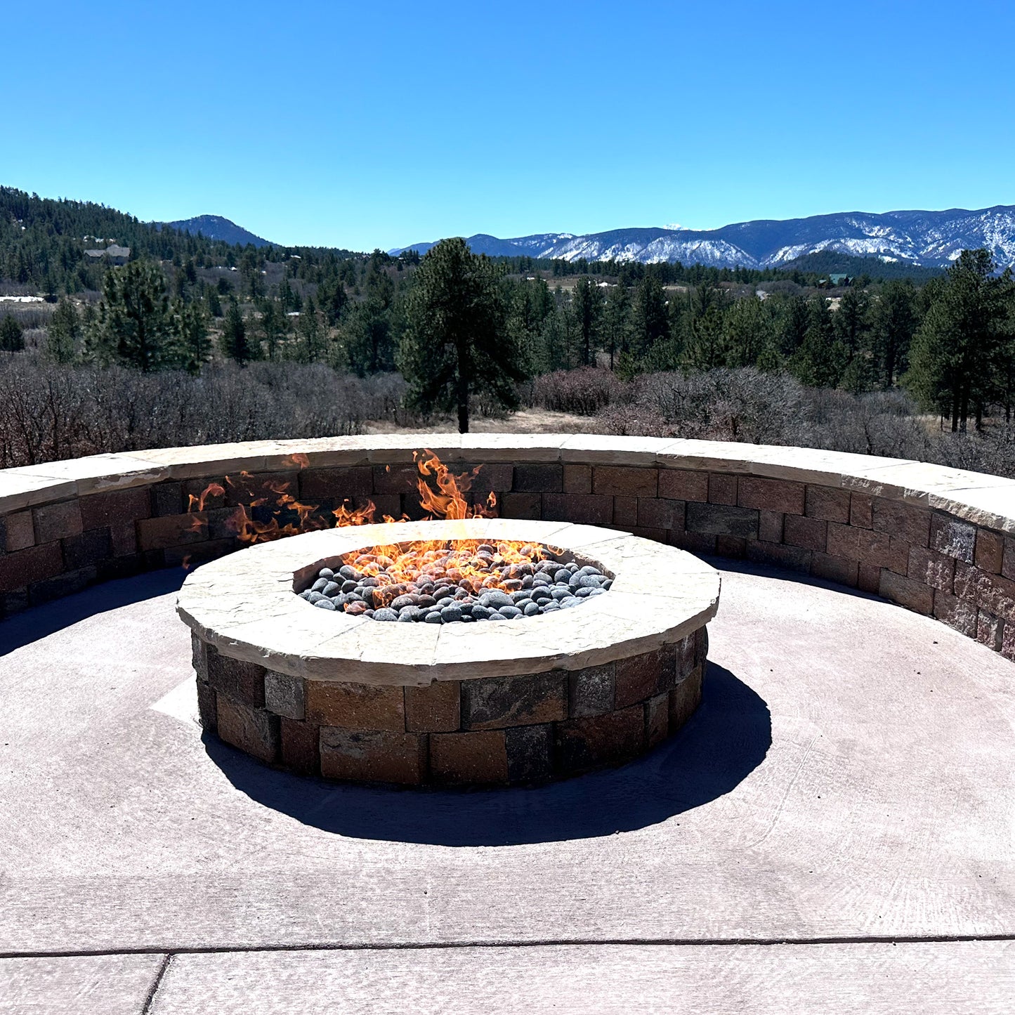 A fire burning in an outdoor fire pit built with 12″ Burner, 13-18″ Torpedo Penta custom Burner Kit.