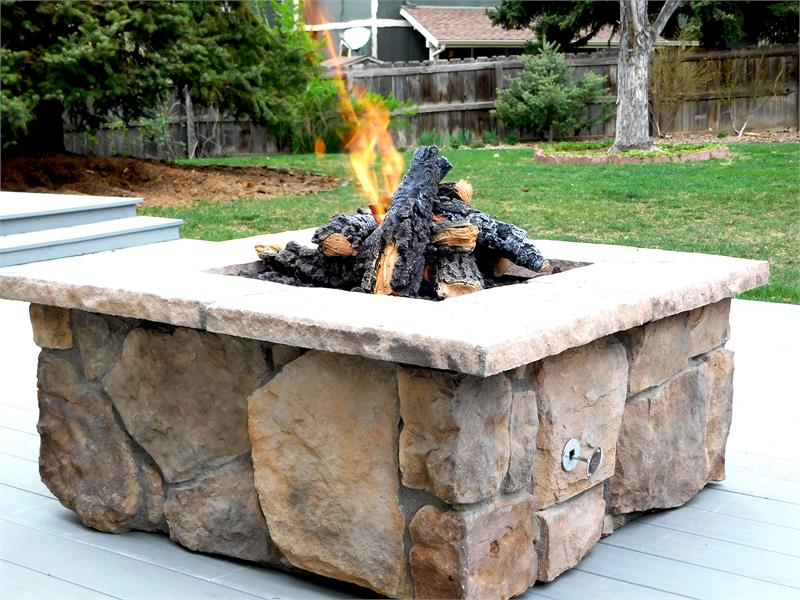 Custom stone fire pit with "Sienna" moss rock base and "Brown" cap stones