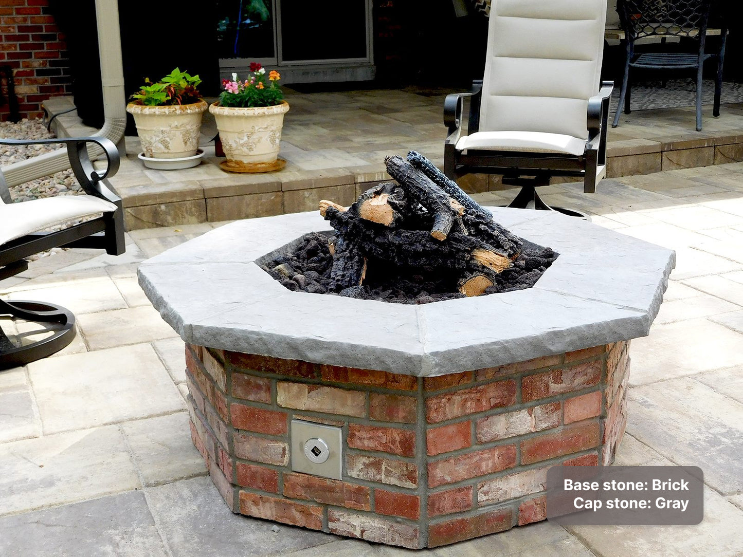 custom stone fire pit with thin brick base and Gray cap stone, with a log set